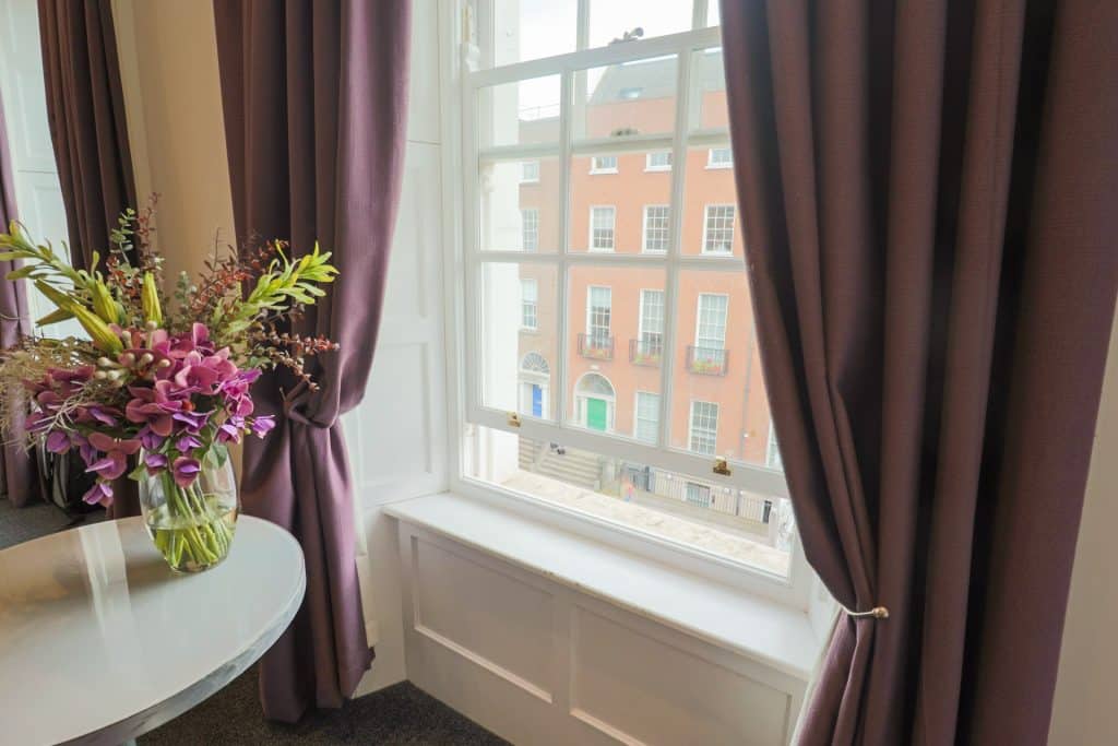 View of the window with flowers on table curtains opened